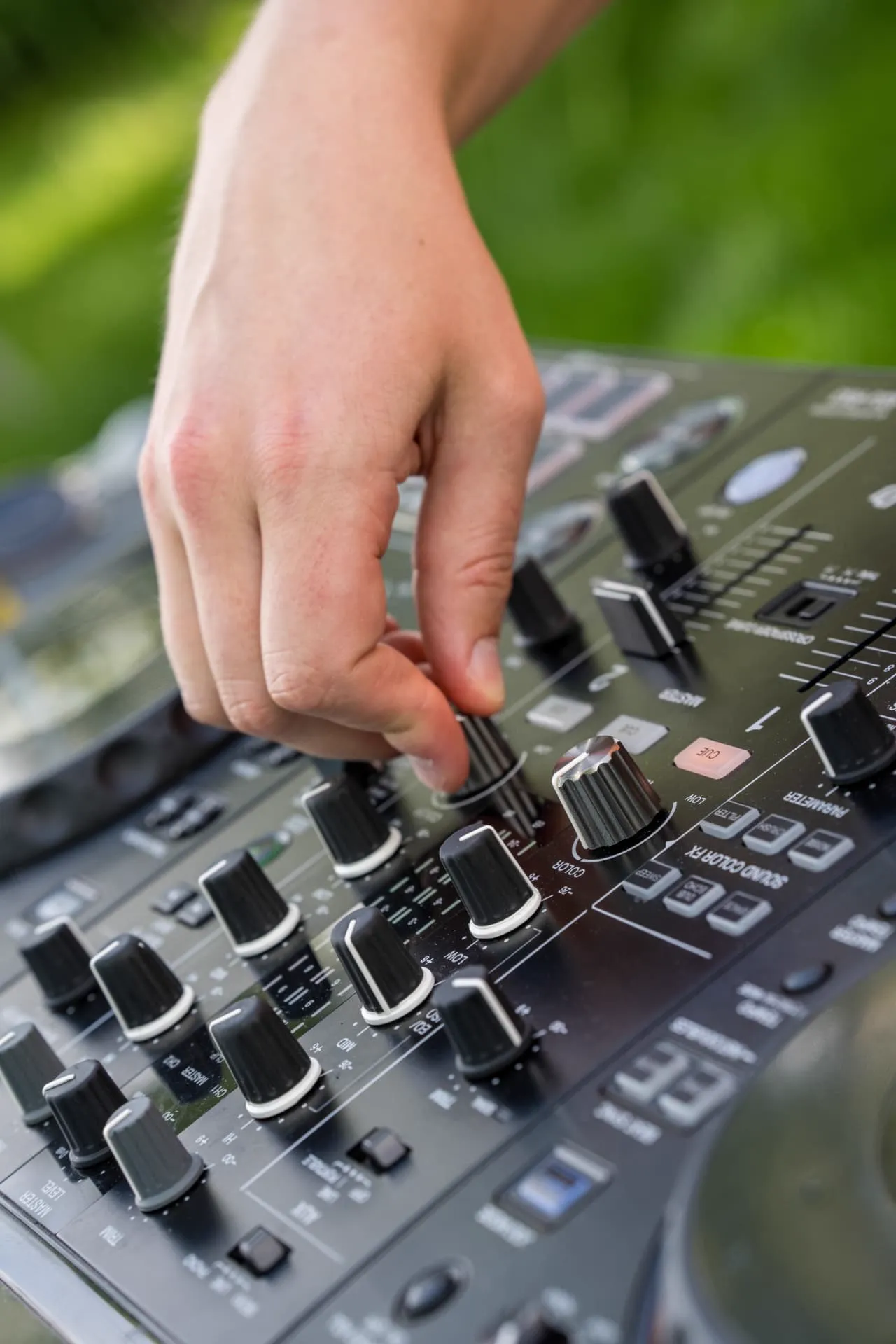 Mains du DJ sur la console de mixage pendant la soirée