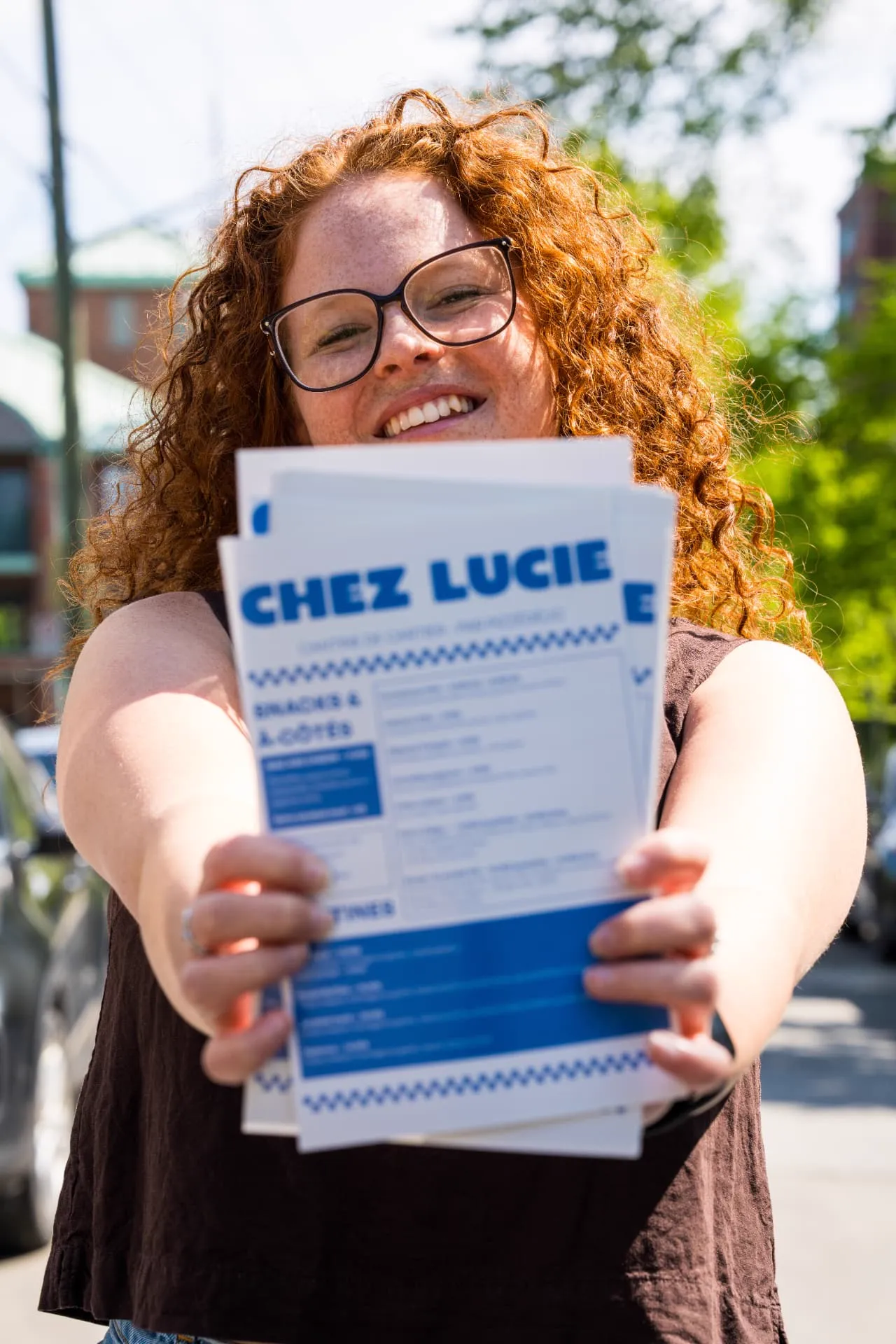 Employée présentant les menus imprimés de la Cantine chez Lucie