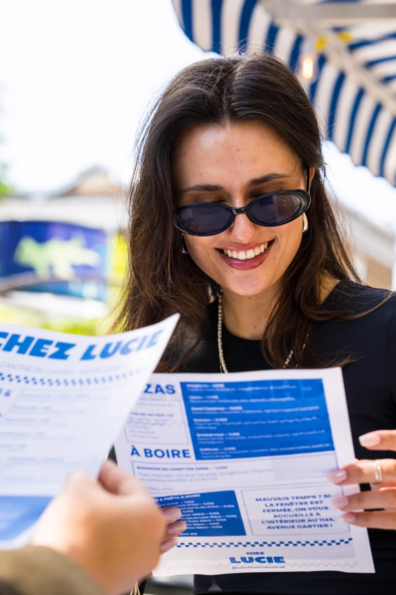 Cliente qui consulte le menu de la cantine sous la terrasse