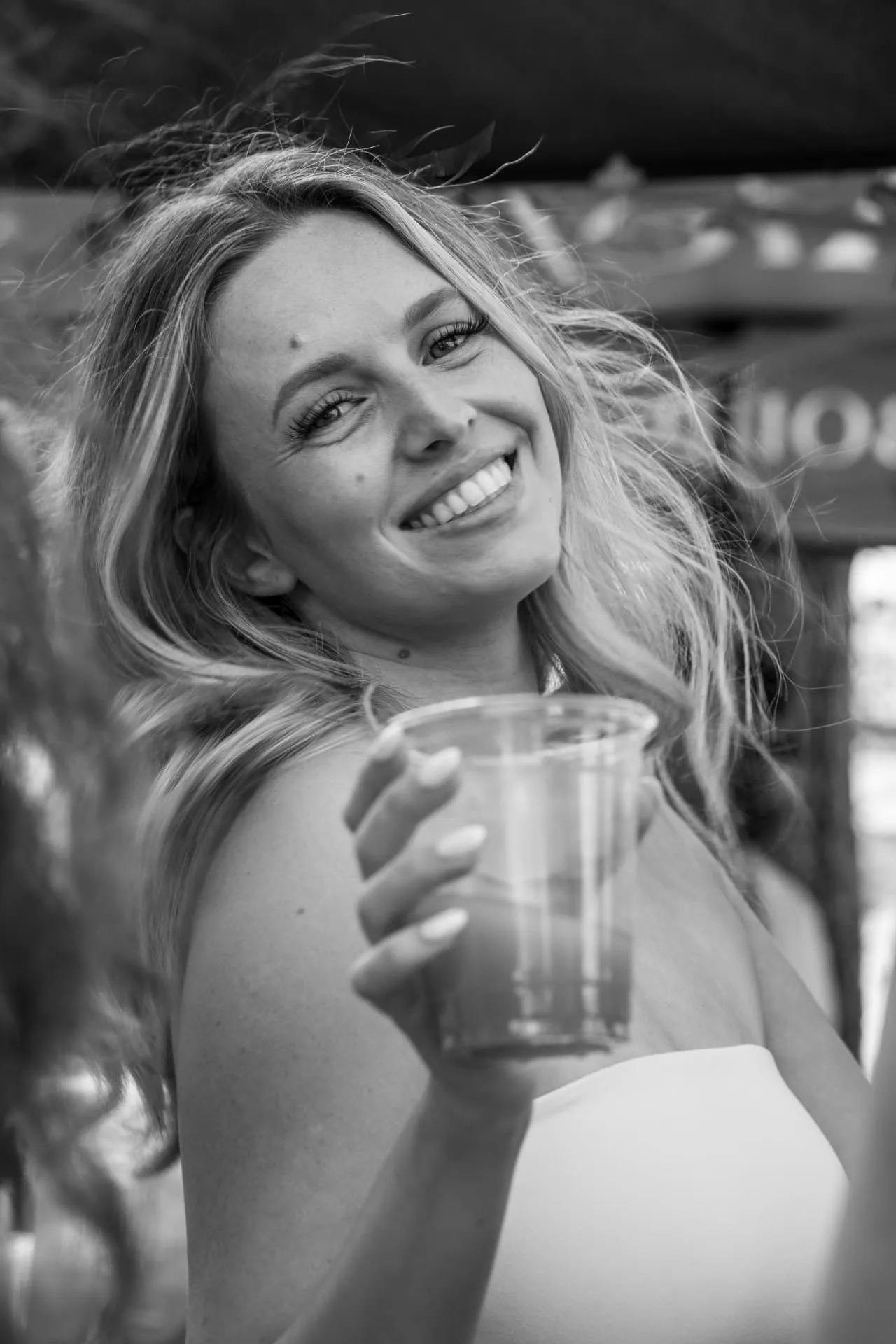 Invitée souriante avec un verre pendant la soirée