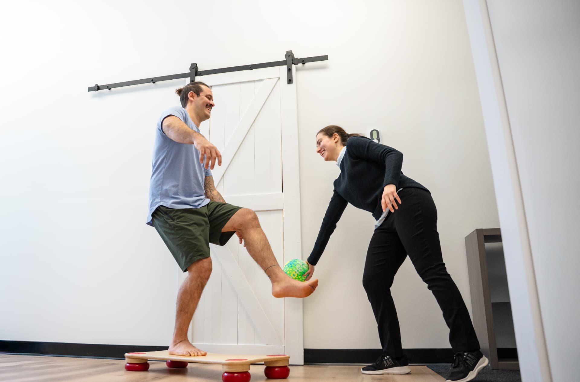 Patient pratiquant un exercice d'équilibre accompagné par Équili Physio
