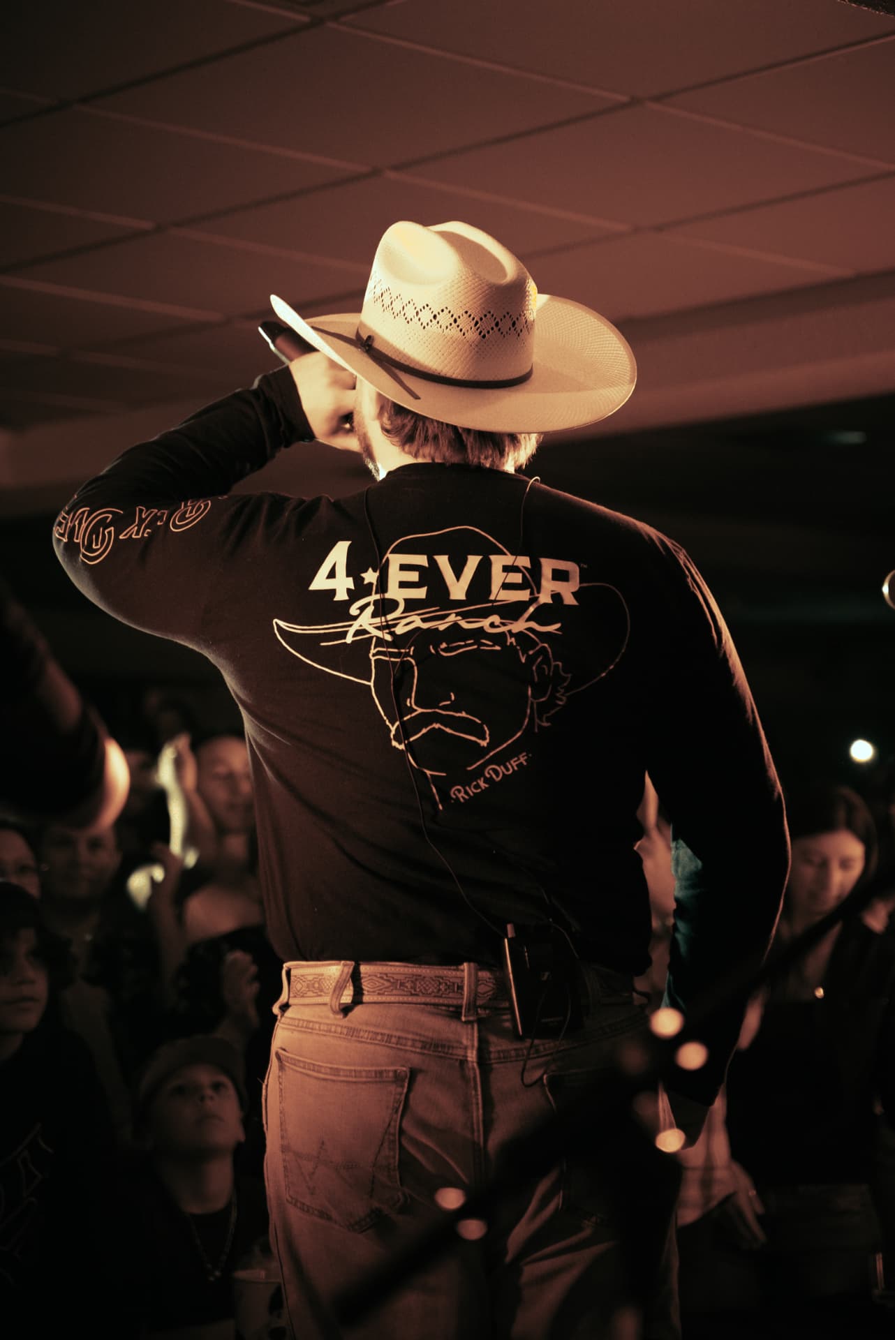 Arpin Lépine de dos sur scène avec son chapeau de cowboy