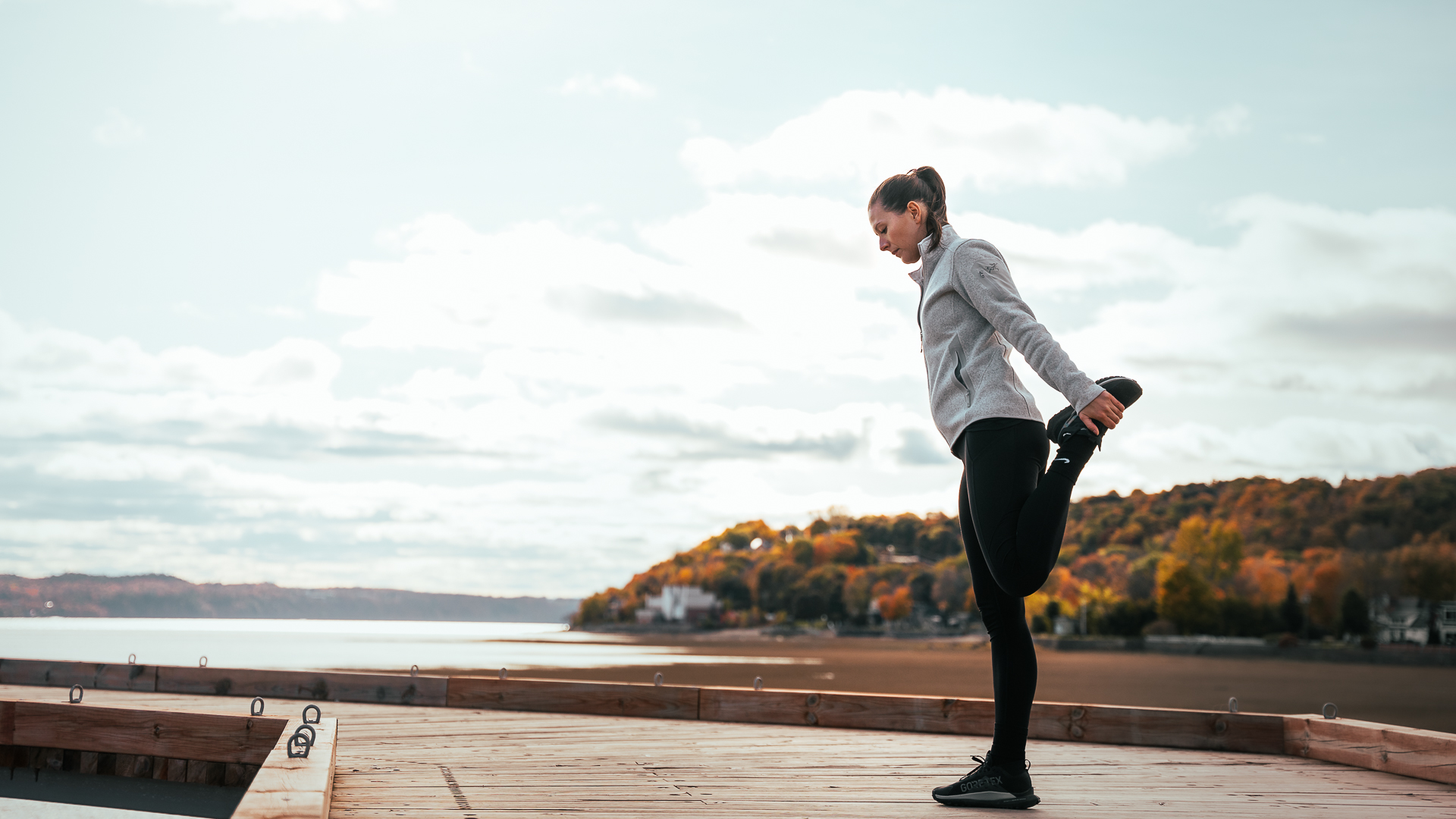 Étirements au bord du fleuve avant une séance d'entraînement