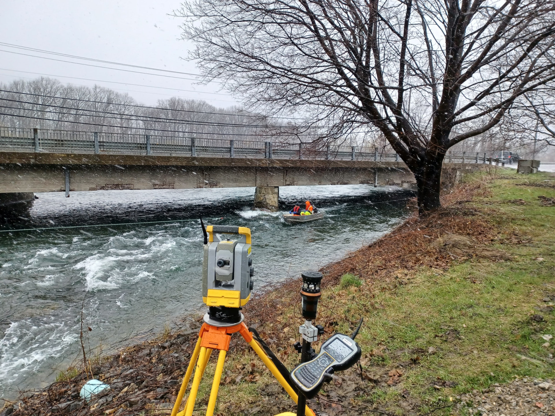 Instrument d’arpentage Géniarp près d’une rivière et d’un pont.