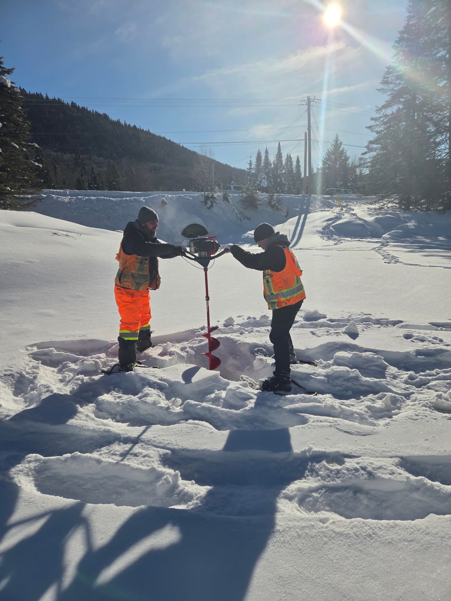 Forage dans la neige pour installer un repère de mesure en hiver.
