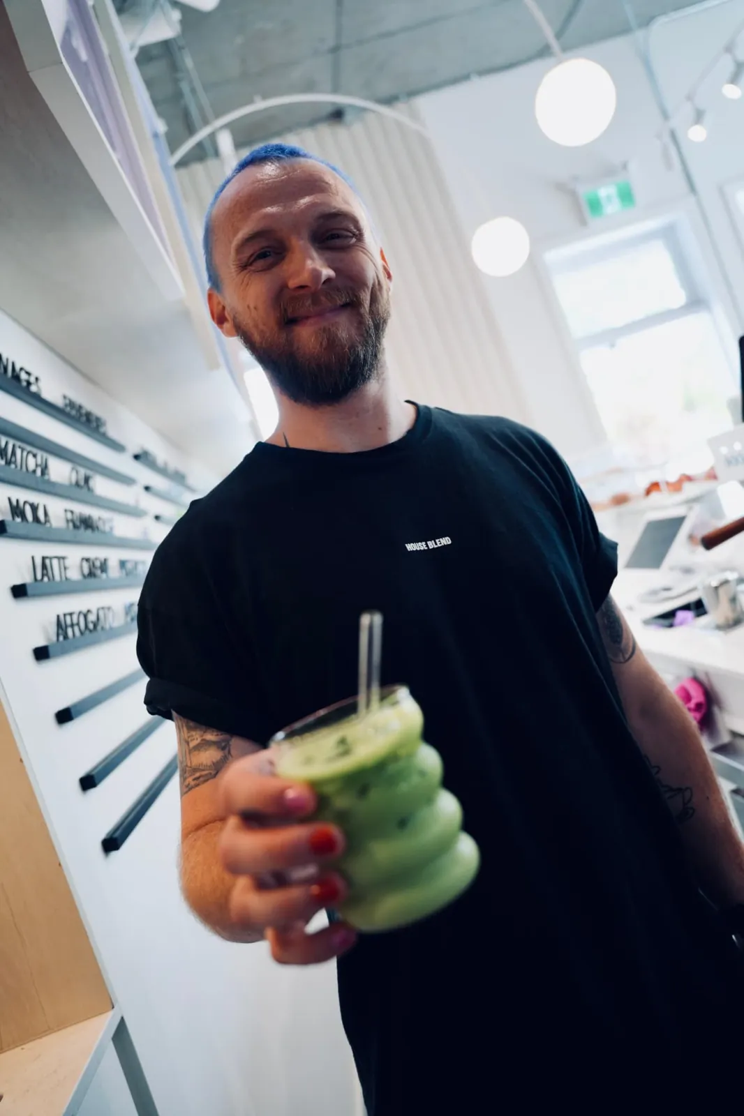 Barista d'un café partenaire qui présente un matcha glacé aux coureurs