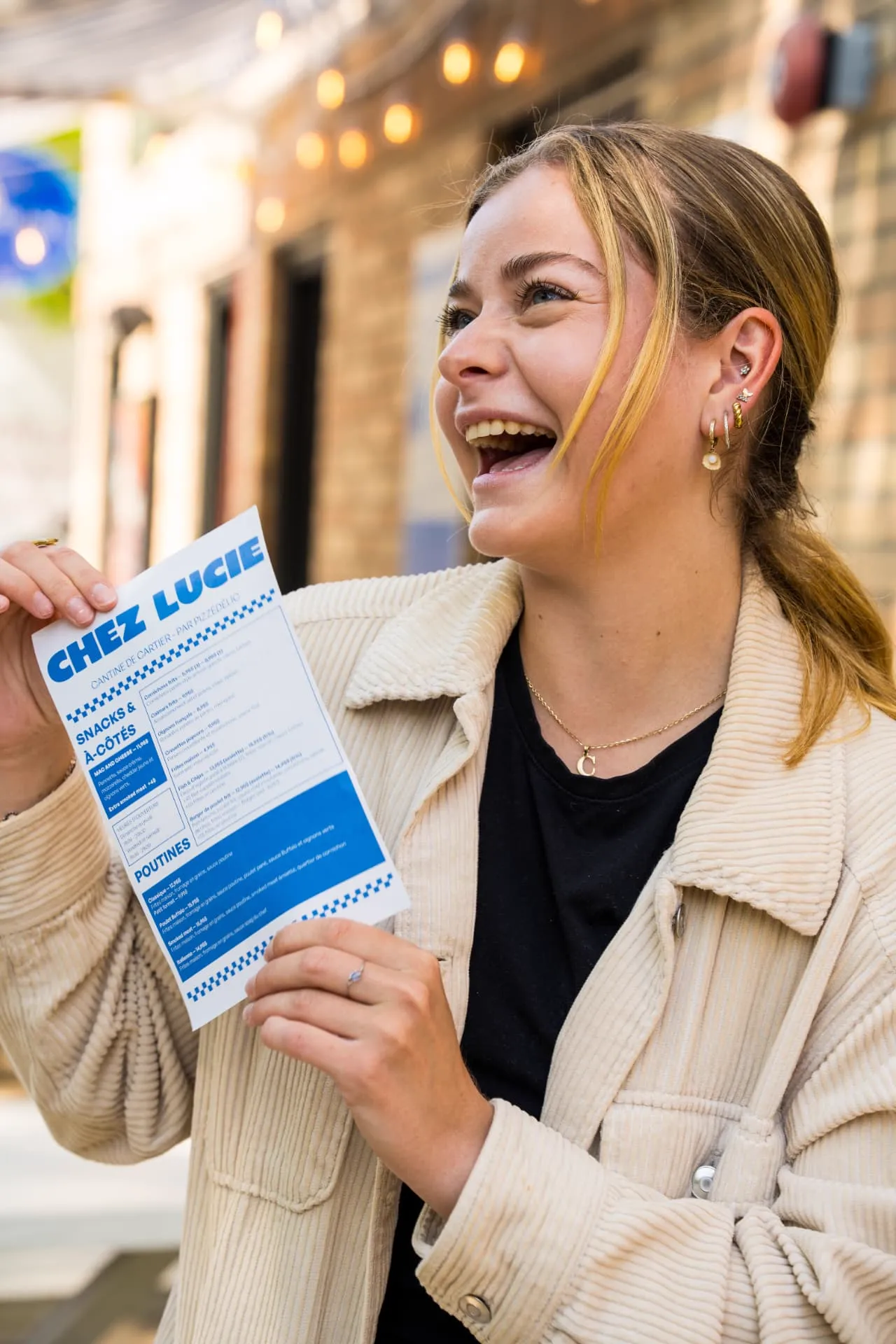 Cliente souriante avec le menu de la Cantine chez Lucie