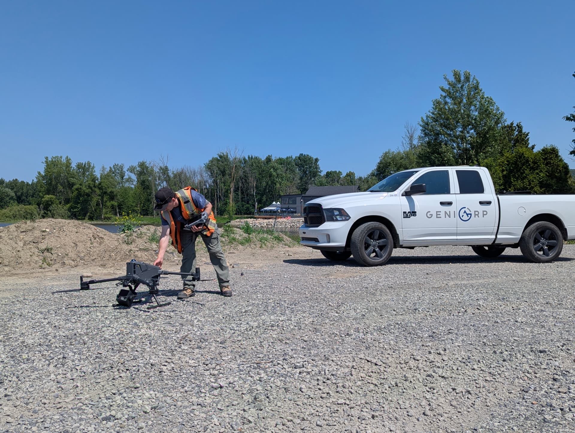 Technicien Géniarp prépare un drone d’arpentage devant le camion de l’entreprise.