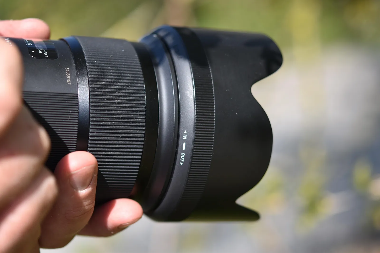 Objectif photo professionnel tenu en main