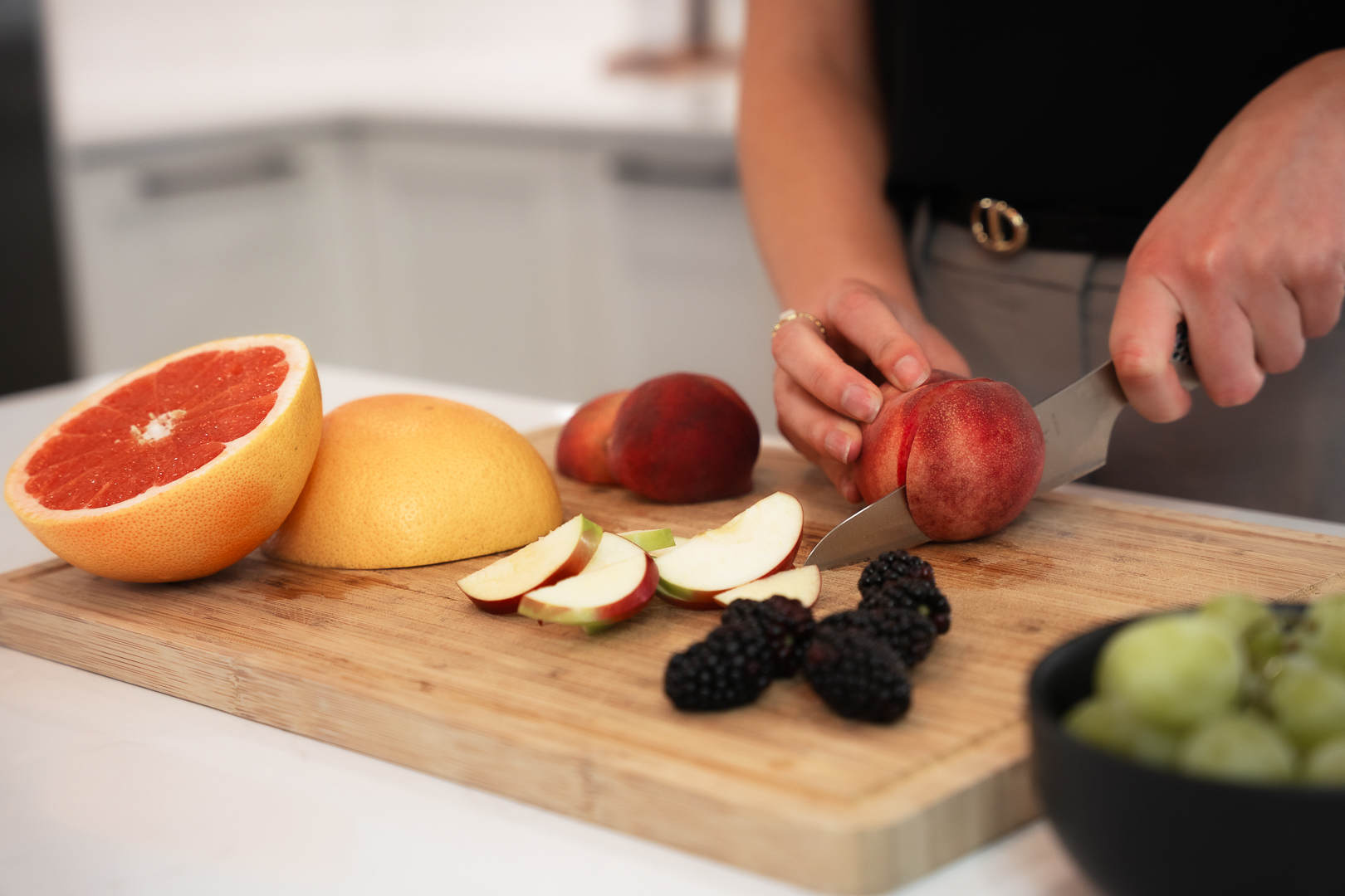 Catherine Bélanger coupant des fruits frais sur une planche en bois