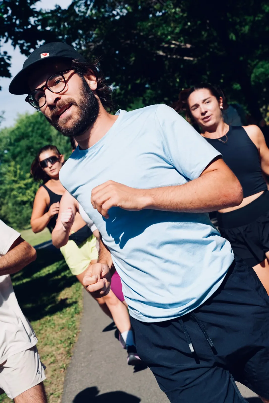 Coureur en pleine foulée entouré du groupe lors d'une sortie hebdomadaire